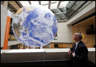 A man looks at a giant globe A man looks at a giant globe