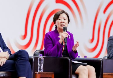 Nancy Ip speaking into microphone on stage.