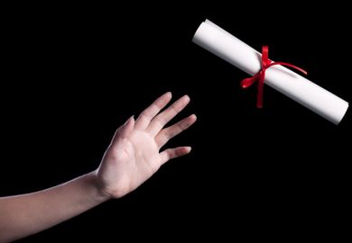 A hand reaching out to take a rolled up copy of a degree certificate