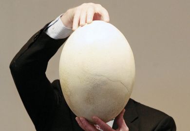 A man holding a large egg A man holding a large egg