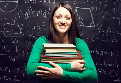 A female student holding a pile of books