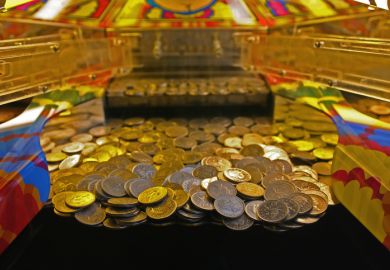 A 10 penny falls arcade machine with focus on the line about to fall. Weston Super Mare, UK.