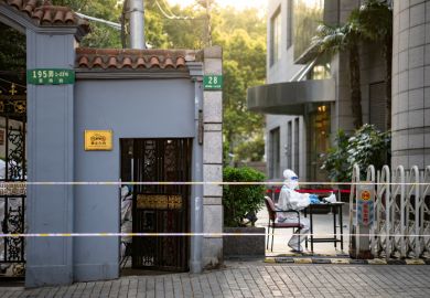 A 'big white' volunteer sits at a compound gate in Shanghai, Xuhui district during 4 day city wide lockdown as it drags on past the planned finish date as Shanghai struggles to control a large outbreak of COVID-19.