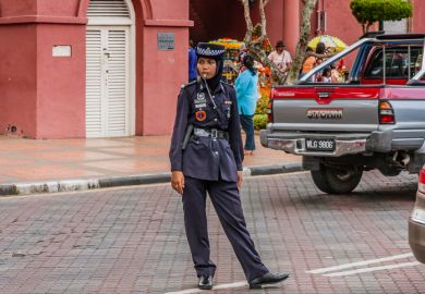 A traffic policewoman wearing hijab at duties, Malacca, Malaysia A traffic policewoman wearing hijab at duties, Malacca, Malaysia