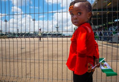 A young girl was seen holding Nigeria Flag behind a barricade during 62nd independence day celebration at eagle square, Abuja, Nigeria