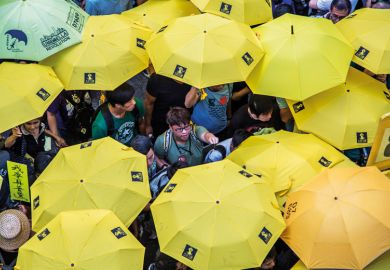 Activists hold yellow umbrellas outside Hong Kong Central Government Complex