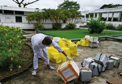 African worker in PPE inspects supplies African worker in PPE inspects supplies