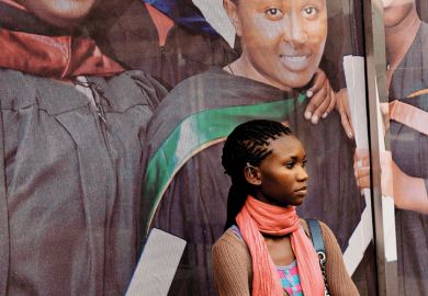 African woman standing in front of university sign