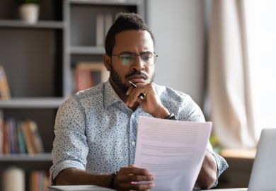 An African academic reads a thesis