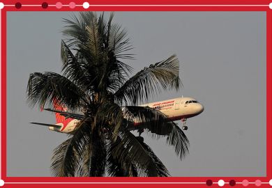 An Air India passenger flight prepares for landing at the Biju Patnaik International Airport seen behind a tree, illustrating branch campuses in India. 