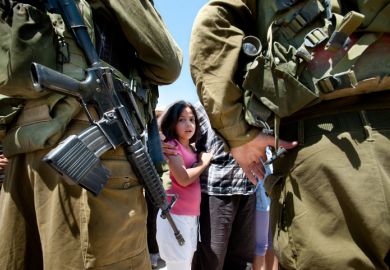 Al-Walaja, Occupied Palestinian Territories - August 27, 2011 A Palestinian girl confronts Israeli soldiers in a protest against the encirclement of the West Bank town of Al-Walaja by the Israeli separation barrier.