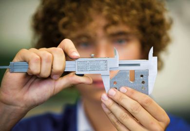 An apprentice with a caliper