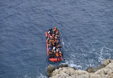An inflatable boat filled with refugees and other migrants approaches the south coast of the Turkey