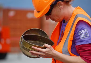 An unidentified geologist inspects rock samples while drilling to 1300 metres on the Deep Fault Drilling Project, Whataroa, New Zealand