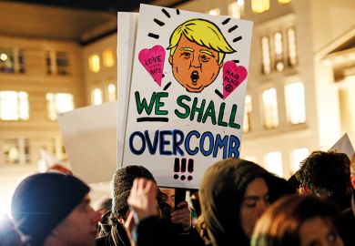 Anti-Trump demonstrators holding placard