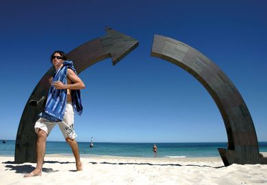 A swimmer walks past "Roundabout" a sculpture by Jennifer Cochrane of Western Australia  to illustrate Losses on the home front proving costly for Australian universities