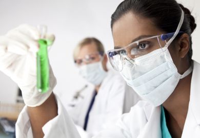 An Asian scientist holding a test tube An Asian scientist holding a test tube