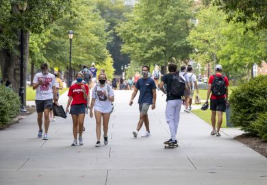 August 20, 2020 During the COVID-19 pandemic, students wear face coverings while walking on campus on the first day of the Fall semester at the University of Georgia.