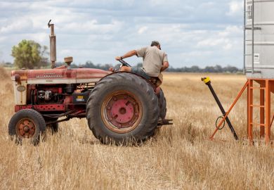 Moree, Australia - November 27, 2010: A farmer uses and old vintage tractor on a farm in Moree a major agricultural area in New South Wales, Australia.