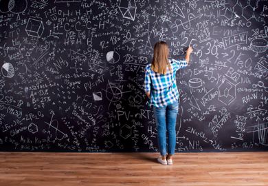 A woman writing on a blackboard that is covered in writing
