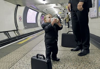 Man and little boy wearing suits standing on tube platform Man and little boy wearing suits standing on tube platform