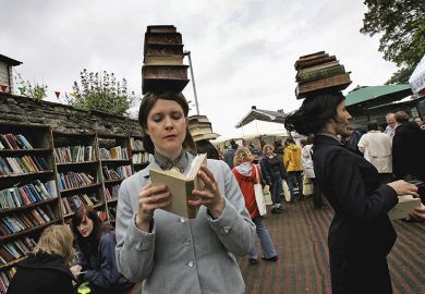 People balancing books on their heads at the Hay Literary Festival. To illustrate librarians needing to discard underused books due to lack of shelf space. People balancing books on their heads at the Hay Literary Festival. To illustrate librarians needing to discard underused books due to lack of shelf space.