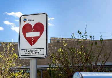 Barcelona, Spain - April 2, 2023. A stark road sign stands against a bright sky, warning of the dangers of gender-based violence in an effort to guide and communicate with viewers.