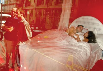 Max Whatley and Meg Zakreta are watched by pedestrians as they lie in bed in a public artwork known as “No Inhibition” in the window of the Blink Gallery, August 29, 2002, in London, England, illustrating review of book On Getting Off: Sex and Philosophy 