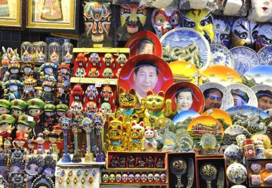 Beijing, China - October 19, 2014 - A souvenir stall at a Beijing night market selling Xi Jinping face plates and other kitsch