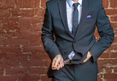 A suited man tightens his belt