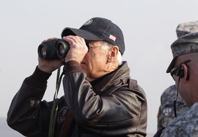 Joe Biden looks through binoculars toward North Korea