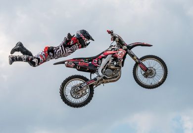 Motocross rider in mid-air illustrating university staff choosing to homeworking off campus