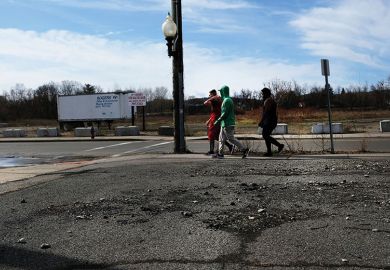 Three people walking on deserted street in Binghamton NY