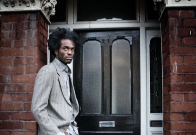 A Black man waits in a doorway A black man waits in a doorway illustrating opinion article about equity in higher education