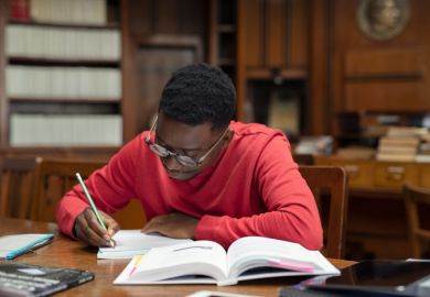 A black student studies in a university library A black student studies in a university library