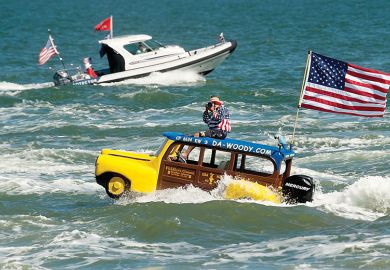 Man in boat shaped like a car with the American flag