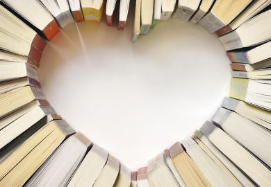 Books arranged on table in shape of heart Books arranged on table in shape of heart