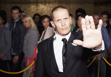 bouncer with arm outstretched outside nightclub