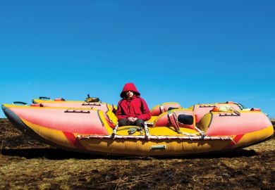 Boy sitting alone on boat in field