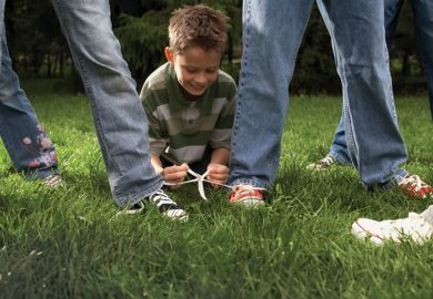 Boy ties two people's shoes laces together
