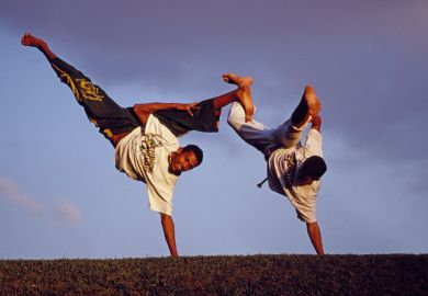 Brazilian men performing capoeira outdoors Brazilian men performing capoeira outdoors
