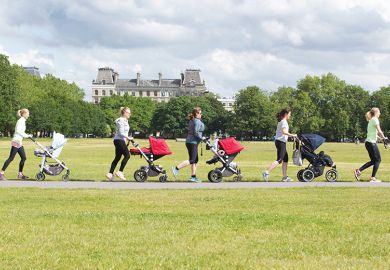 Women push children’s buggies across a park