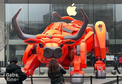 People look at a bull statue set up in front of an Apple store at Sanlitun, 2021 in Beijing, China. To illustrate if the academy can rein in Big Tech.