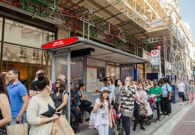 People wait at a bus stop