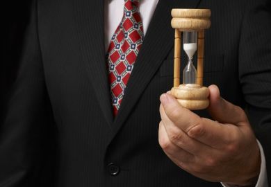 Businessman holding an egg timer Businessman holding an egg timer