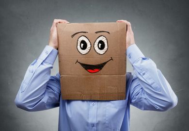 Businessman with smiley face cardboard box on his head