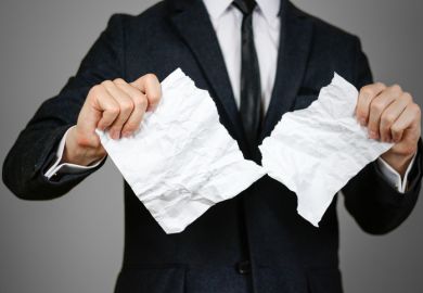 Businessman tearing hands crumpled sheet of A4 paper