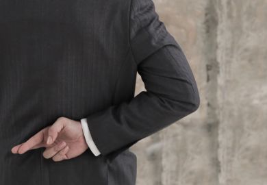 Businessman with his fingers crossed behind his back