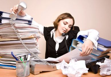 Businesswoman working at cluttered desk