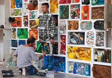 Camouflage artist Liu Bolin at the Surfrider Foundation in Biarritz, blended into a background of rubbish, 2017